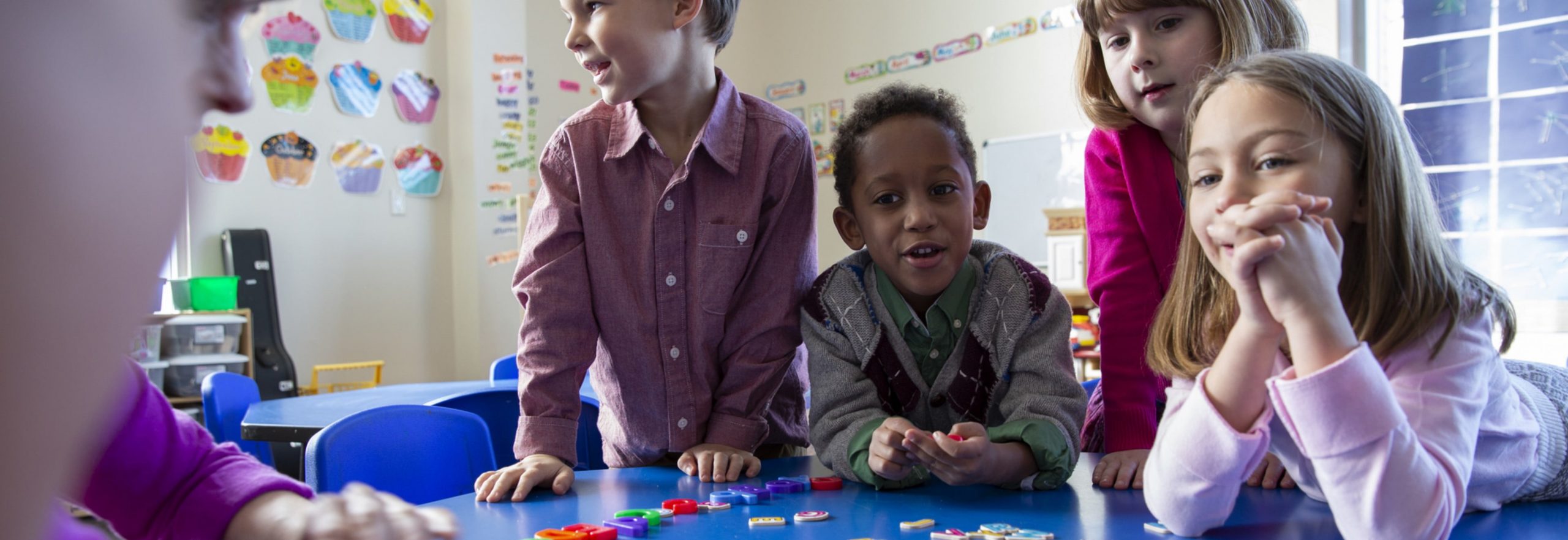 Kids Playing with letters on a table.