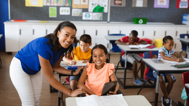 Teacher and Student smiling in a classroom setting.